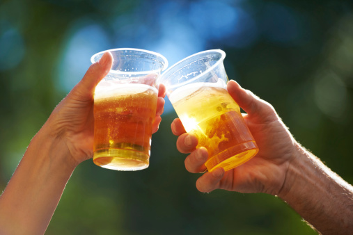 Cropped view of two people saying cheers with their beer cups