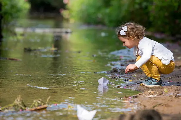 Photo of Little girl with a paper boat