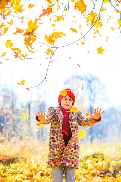 istock Little girl play with fallen leaves 508550759