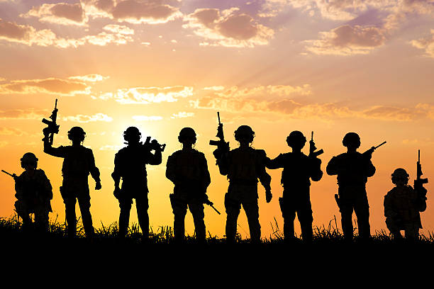 silhouette of  Soldiers team with sunrise background silhouette of  Soldiers team with sunrise or sunset background. battle photos stock pictures, royalty-free photos & images