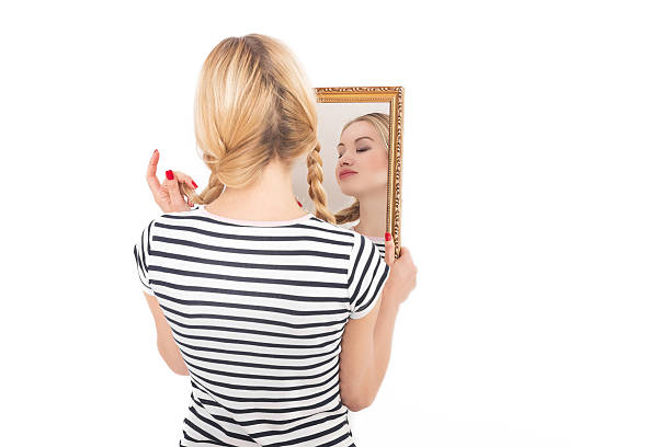 istock Young woman looking to self in mirror 508551596