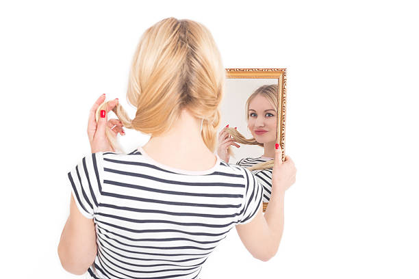 Young woman looking to self in mirror