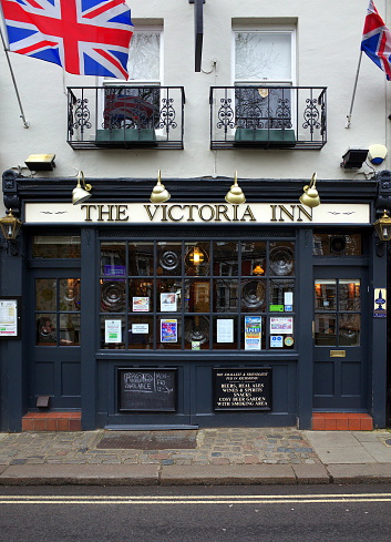 London, England - February 04, 2016: Exterior of the The Victoria Inn public house in Richmond, London. An example of an english pub with Union Jack flags flying above the entrance