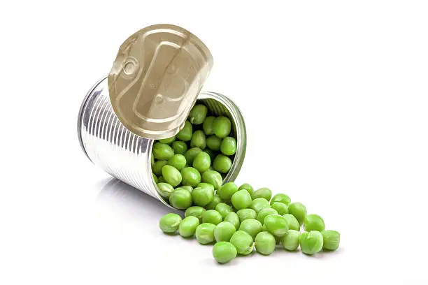 Opened tin with green peas. Isolated on white.