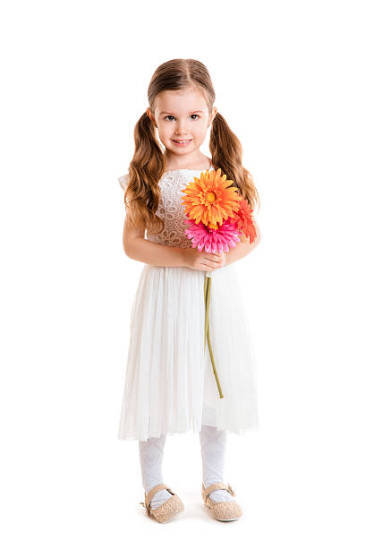 Shot of a happy little girl looking at the camera and smiling while standing in the middle of a dirt road