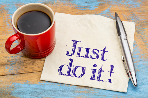 Just do it motivational advice on napkin with a cup of coffee. Motivation concept.