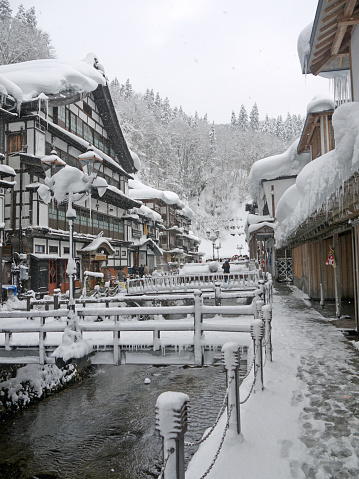 Small japanese onsen village in winter. River with bridges.