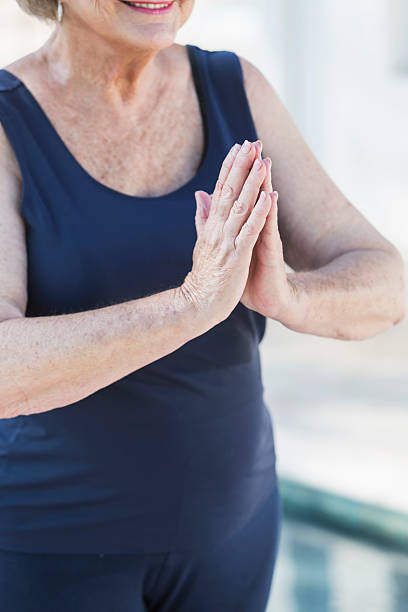 istock Cropped view, senior woman standing with palms together 508577702