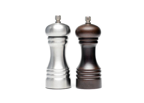 Salt and Pepper Close up of mass produced salt and pepper grinders on a white background. pepper shaker stock pictures, royalty-free photos & images