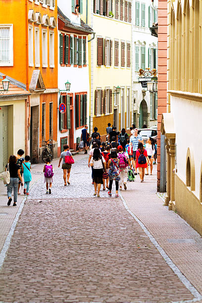 Heidelberg, Germany - July 22, 2015: A large group of asian tourists is passing pedestrian zone and street down from Haupstraße to Neckarstaden in Altstadt of Heidelberg.