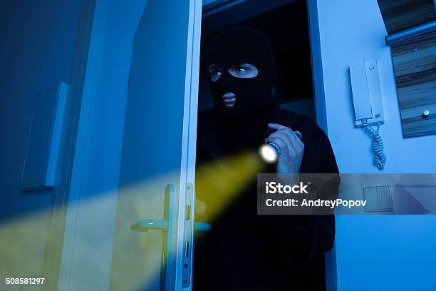 Thief Holding Flashlight While Entering Into House Stock Photo - Download Image Now - Adult, Adults Only, Blue