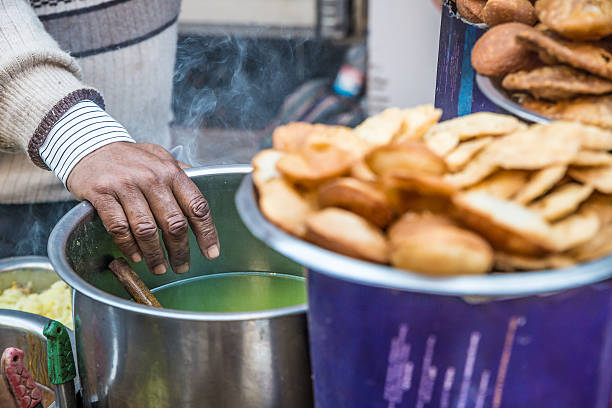 Indian street food Man cooking panipuri on a Delhi street. panipuri stock pictures, royalty-free photos & images