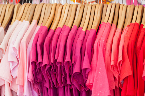 row of pink shirts on clothes hanger