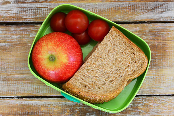 istock School lunch with brown bread sandwich, red apple, cherry tomatoes 508585890