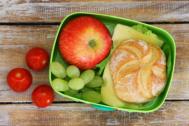 école boîte déjeuner avec fromage "sandwich", une pomme, raisins, tomates de cerisier - lunch box lunch red apple photos et images de collection