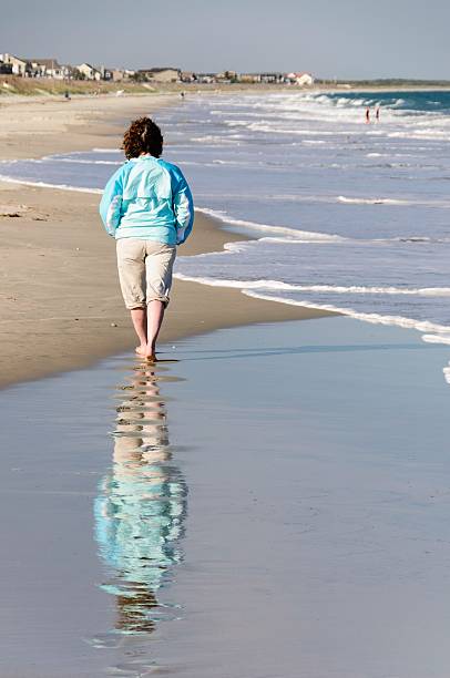 środku wieku kobieta spaceru na plaży w południe carolina - south carolina beach south north carolina zdjęcia i obrazy z banku zdjęć