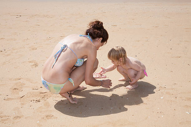 istock baby and mother picking sea shells 508589146