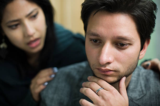 Sad couple in crisis, looking down, feeling lonely and stressed, seeking support and connection in their troubled relationship