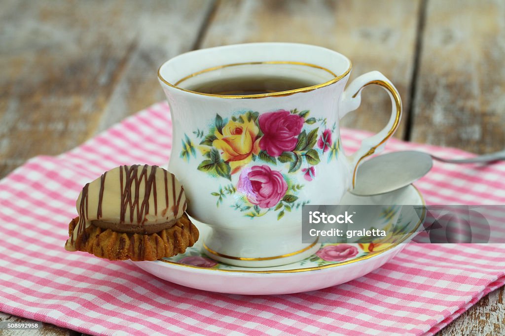 Tea in colorful vintage porcelain cup with chocolate, toffee cookie Tea in colorful vintage porcelain cup with chocolate and toffee crunchy cookie Afternoon Tea Stock Photo