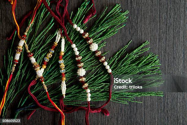 Multi Colored Rakhi With Plants On Wooden Table Stock Photo - Download Image Now - Anniversary, Asia, Blossom