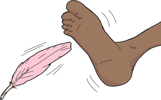 Pink feather tickling toes on human foot