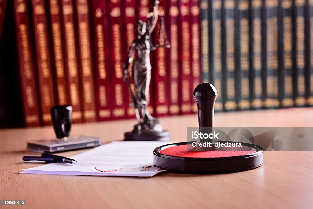 Notary's public working tools. Notary's public working tools. Metal stamper, rubber stamp, pen and statue of Themis Notary Stock Photo