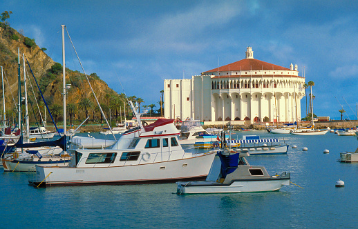 Boats moored in Avalon Harbor on Catalina Island with casino in the background.