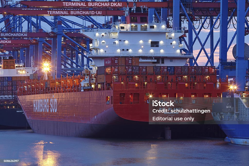 Hamburg - Container vessel loaded and unloaded at terminal Hamburg, Germany - August 8, 2014: The container vessel Rio Blanco (Hamburg Sued) is loaded / unloaded the terminal Burchardkai in the deepwater port Hamburg-Waltershof on August 8, 2014. Blue Hour - Twilight Stock Photo