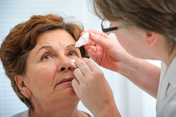Senior woman applying eye drops Doctor helps the patient and gives the eye drops eyedropper stock pictures, royalty-free photos & images