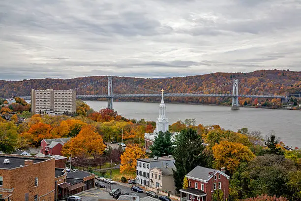 A view of the town of Poughkeepsie, New York, in Autumn with the Mid Hudson Bridge across the Hudson River.