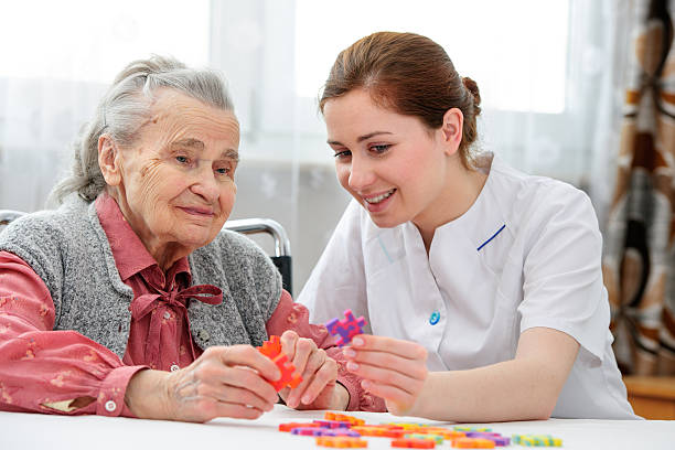 femme âgée avec son ancien soin infirmier - senior adult leisure games playing care photos et images de collection
