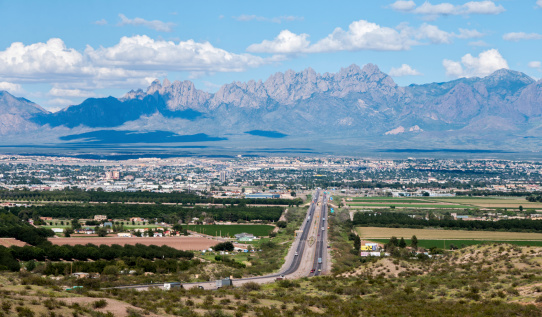 This scenic view shows the city of Las Cruces, New Mexico and the distant Organ Mountains. Interstate 10 is shown entering the city on the west side.