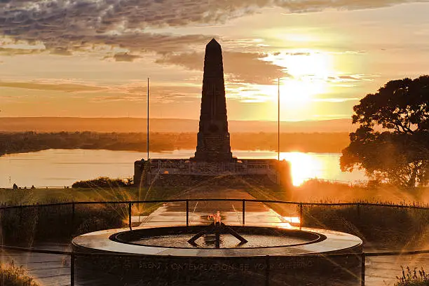 ANZAC commemorate memorial obelisk in Kings park of Perth, Western Australia, at sunrise against rising sun reflecting in swan river