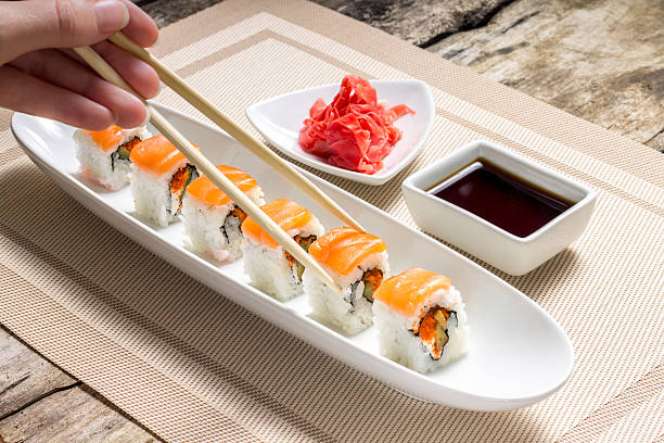 istock Eating with chopsticks seafood sushi rolls with traditional spices 508630175