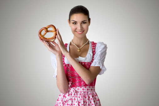 Young woman wearing a dirndl and holding a pretzel - ready for Munich's Beer Fest!