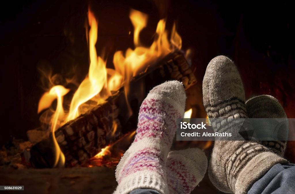 Piedi in calze di lana riscaldamento al caminetto - Foto stock royalty-free di Camino