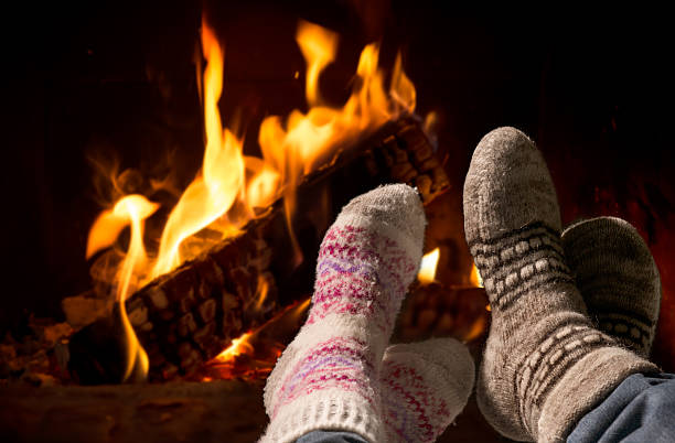 istock Feet in wool socks warming at the fireplace 508631029
