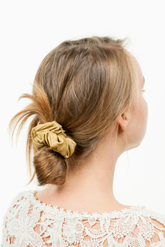 Studio shot of young woman with casual messy chignon hairstyle