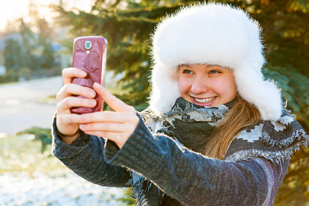 istock Young girl using cell phone in winter 508631161