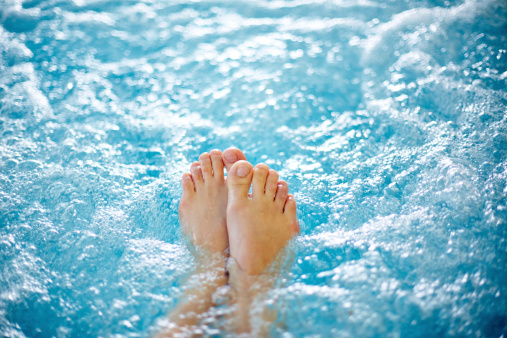 Close-up of female legs in hot tub