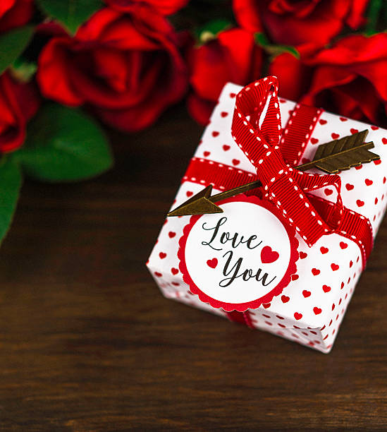istock Valentine rose bouquet on wooden table with gift and message 508631724