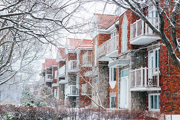 Montreal Neighborhood Residential Apartment Buildings on Snowy Winter Day This is a horizontal, color, royalty free stock photograph of snow falling on a cold winter weather day across residential buildings in Montreal, an urban travel destination in Quebec, Canada. The brick apartment buildings stand in a row. Photographed with a Nikon D800 DSLR camera. montreal stock pictures, royalty-free photos & images