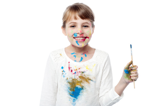 Smiling little girl posing with paint brush