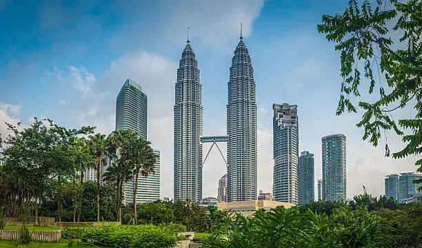 Photo of Kuala Lumpur Petrona Towers skyscrapers framed by foliage KLCC Malaysia