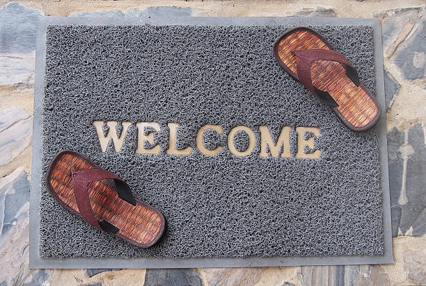 istock welcome mat with brown sandals on floor 508649923