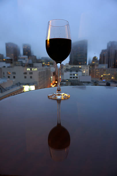 istock Wine glass reflecting on table in front of the city 508650075