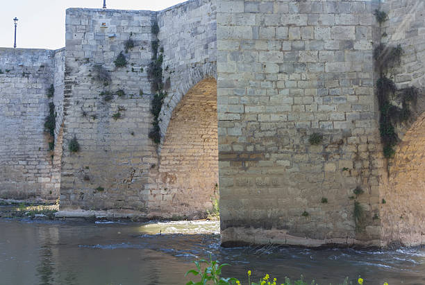 istock Old stone bridge block with arches and water 508650925