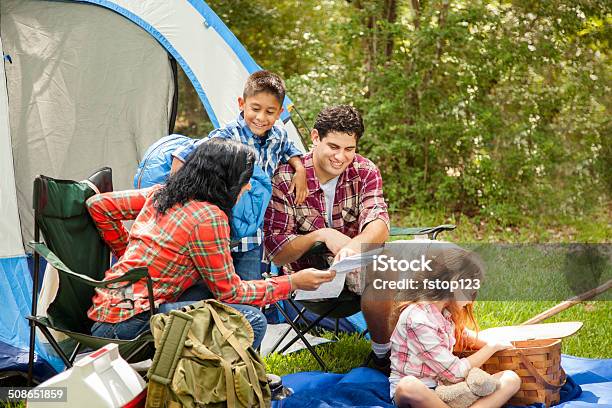 Family Of Four Camping Outdoors In Forest Tent Supplies Stock Photo - Download Image Now