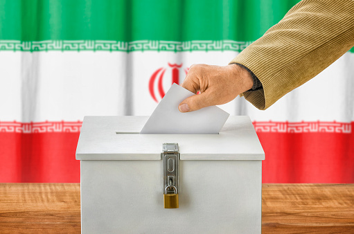 Man putting a ballot into a voting box - Iran