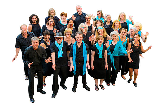 A group of people, men and women, dressed in black and blue or turquoise, standing, smiling and looking at camera. It is an almost white gospel choir. The group is isolated on white.